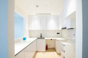 Modern white renovated kitchen with sleek cabinets and marble backsplash, ideal for digital marketing specialists in Dubai. High-quality interior design perfect for promoting luxury homes.