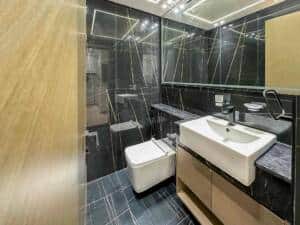 High-end modern bathroom design with black marble tiles, sleek fixtures, and contemporary decor, showcasing sophisticated interior decor for a luxurious Dubai property.