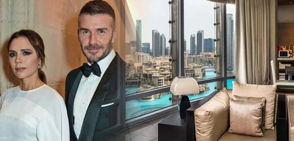 Elegant couple in formal attire standing in a luxury high-rise apartment with panoramic city views of Dubai's skyline and iconic skyscrapers.