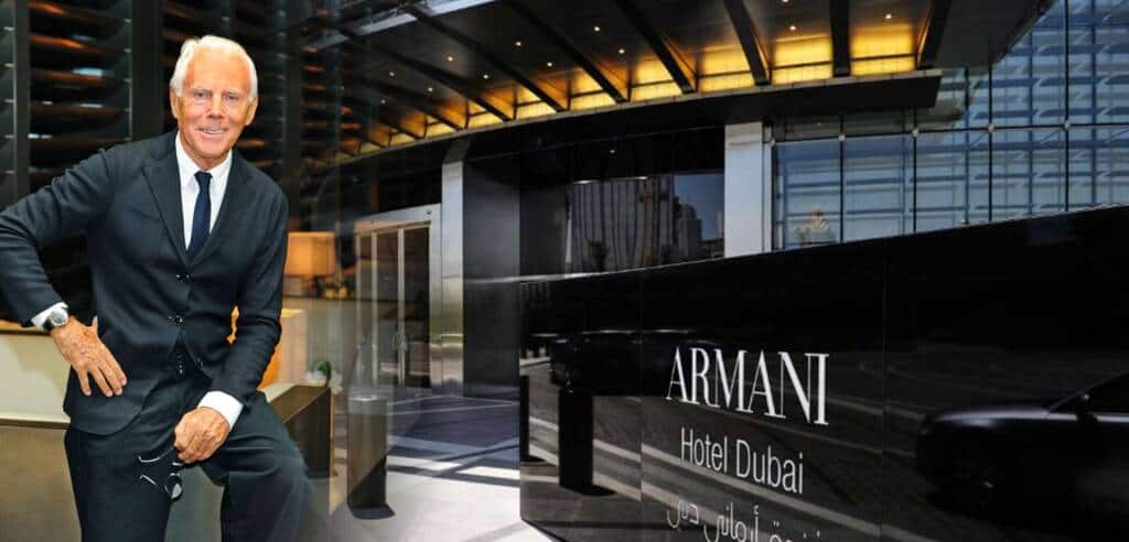 Elegant businessman in a black suit posing at Armani Hotel Dubai lobby.