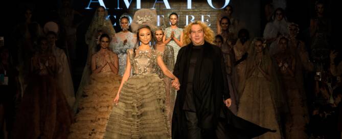 Elegant fashion show in Dubai showcasing haute couture dresses and models on runway with designer and audience, emphasizing luxury fashion and high-end style.