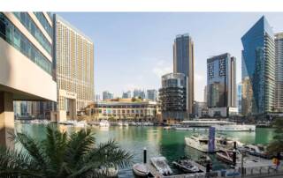 Luxury marina with modern skyscrapers and yachts in Dubai Marina, vibrant downtown skyline, commercial buildings, luxury living, and waterfront views.